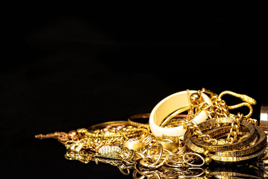 bunch of gold jewelry on black background
