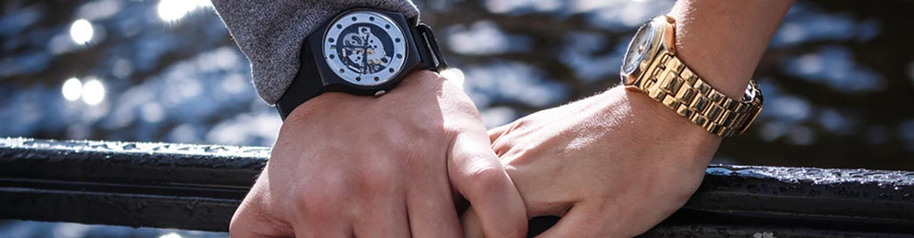 man and womans hand embracing wearing watches
